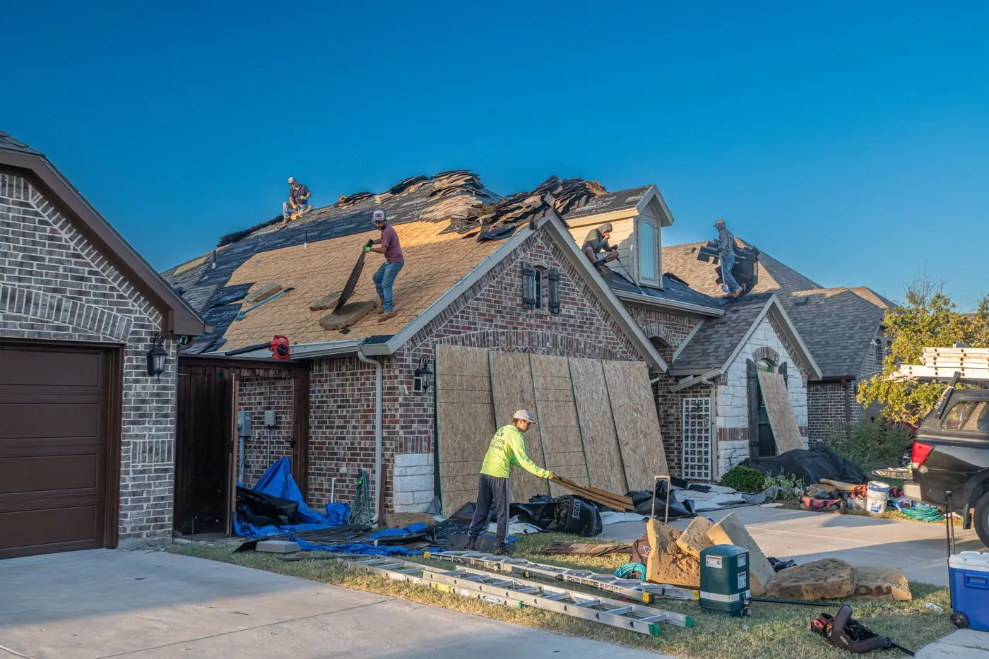 Werkers voeren een dakreparatie uit op het dak van een woonhuis